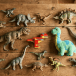 best dinosaur toys for 5 year olds including realistic figures a plush and a brick dinosaur on a wooden surface