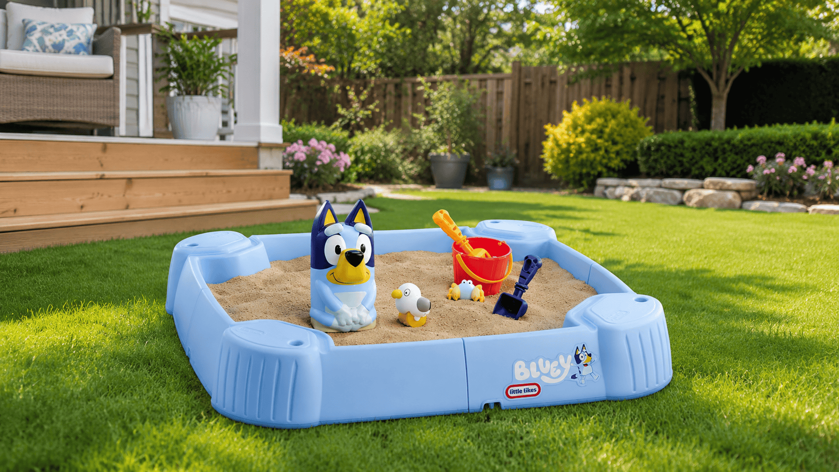 Bluey Little Tikes sandbox with sand toys in a sunny backyard