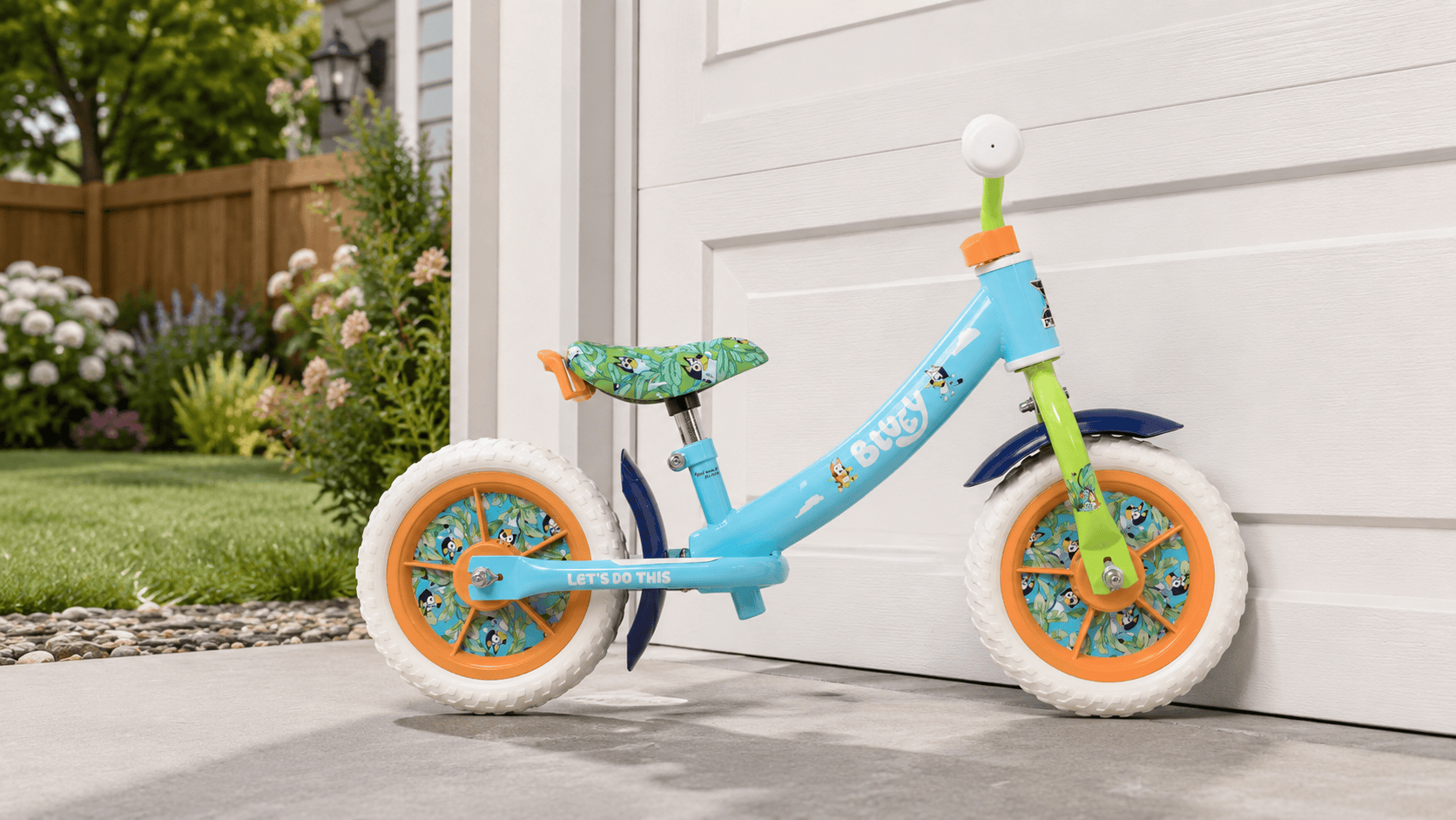 Dynacraft Bluey 10-inch balance bike leaning against a garage door in a sunny backyard setting