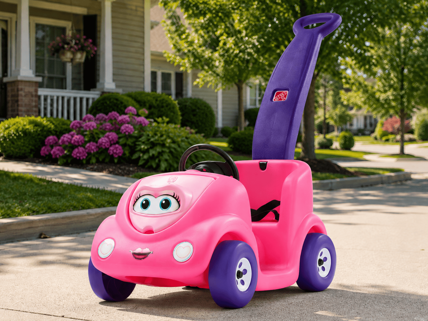 Step2 Push Around Buggy Kids Push Car parked in a sunny driveway in a beautiful neighborhood with green lawns and flowers