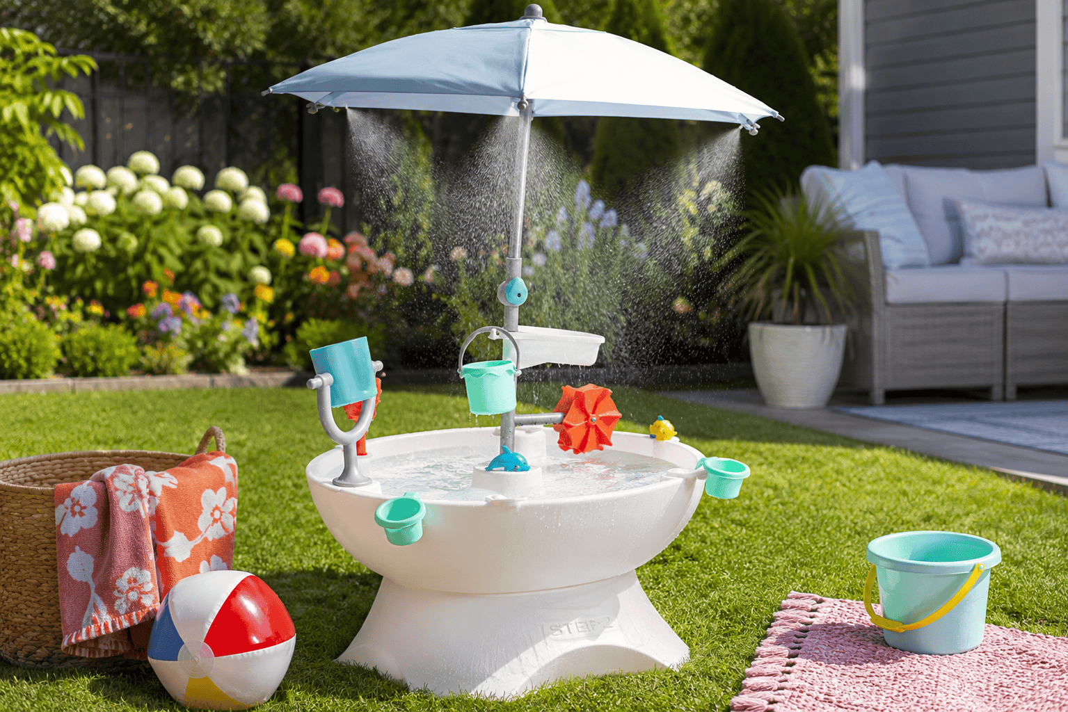 Step2 Sunshine Springs Splash Water Table with CoolBreeze Misting Canopy set up in a sunny backyard with misting water, colorful play accessories, and summer outdoor toys