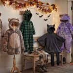 warm halloween costumes for kids displayed in a cozy fall entryway with fleece and plush animal costumes